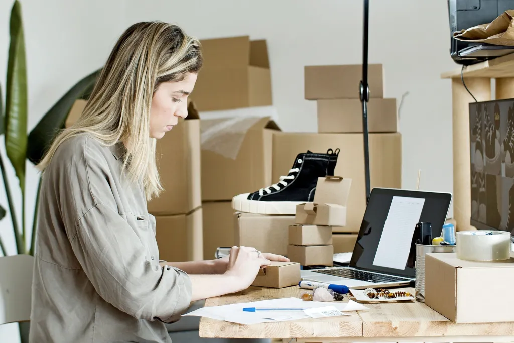 Preparing an order at a laptop next to items to pack