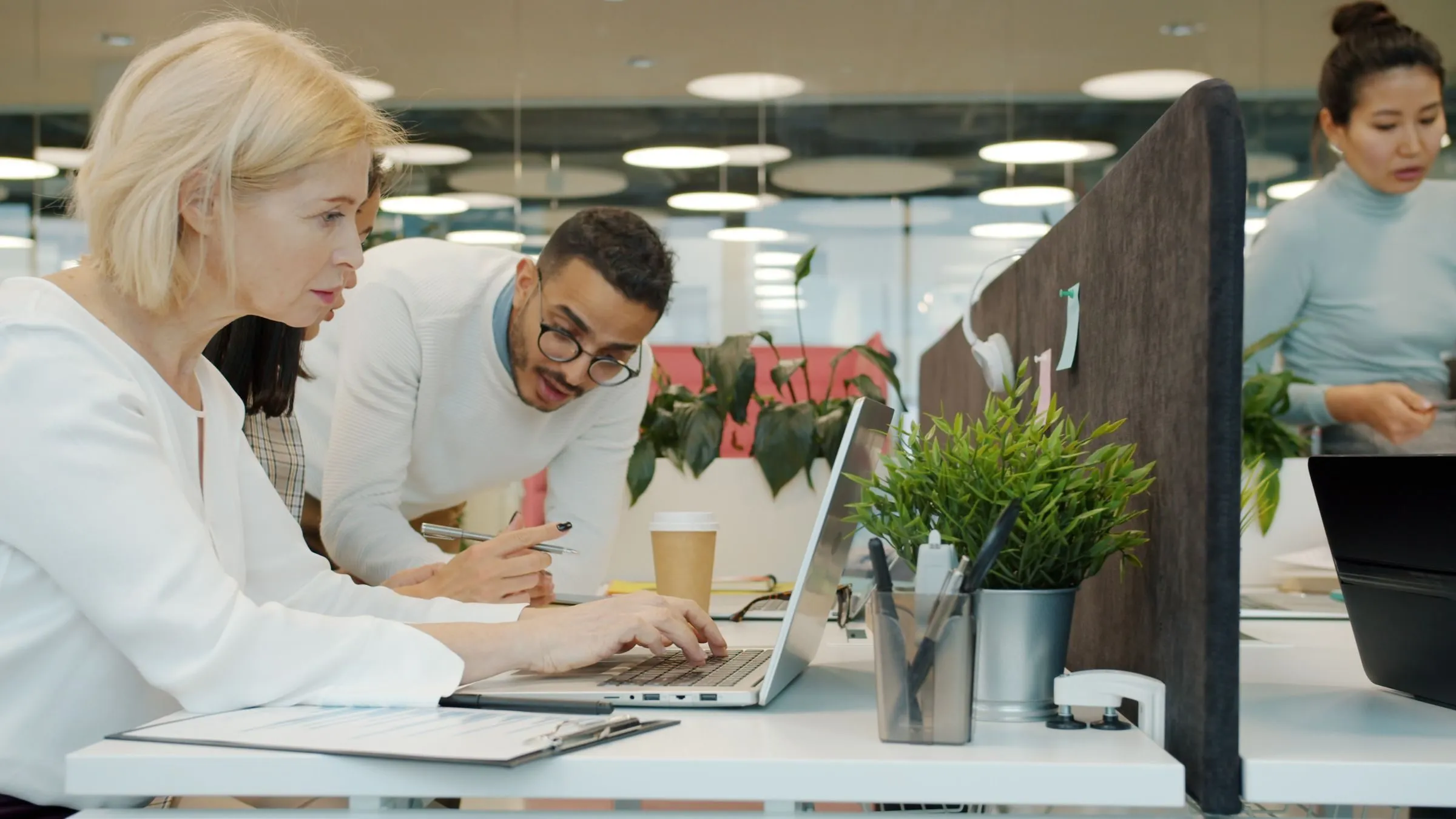 Colleagues reviewing data on a laptop in an office
